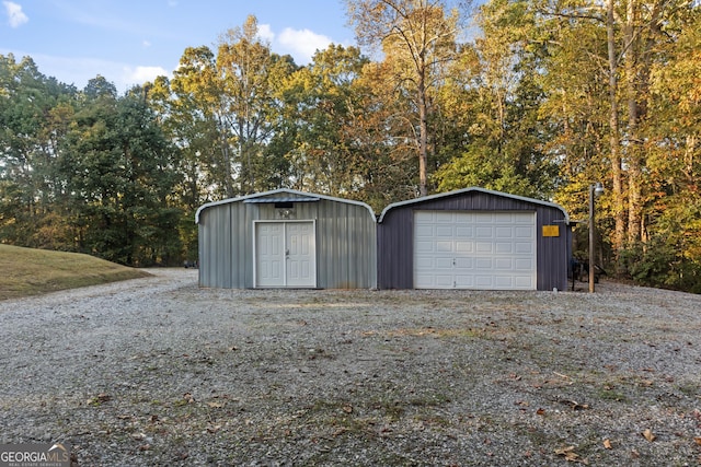 detached garage with gravel driveway