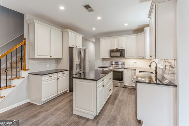 kitchen featuring sink, white cabinetry, light hardwood / wood-style flooring, and stainless steel appliances