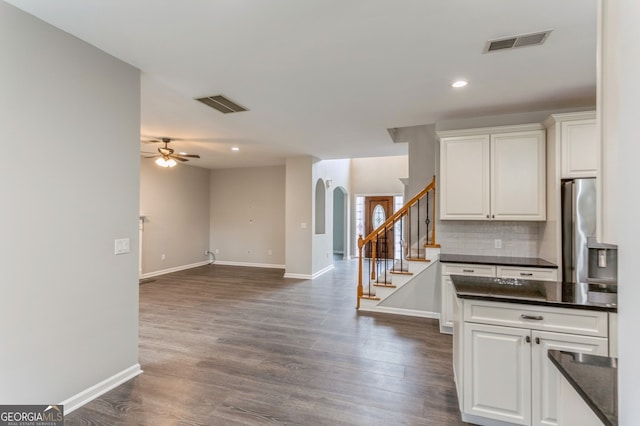 kitchen featuring stainless steel refrigerator, white cabinetry, ceiling fan, and dark hardwood / wood-style flooring