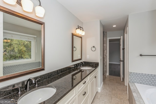 bathroom with vanity and a relaxing tiled tub