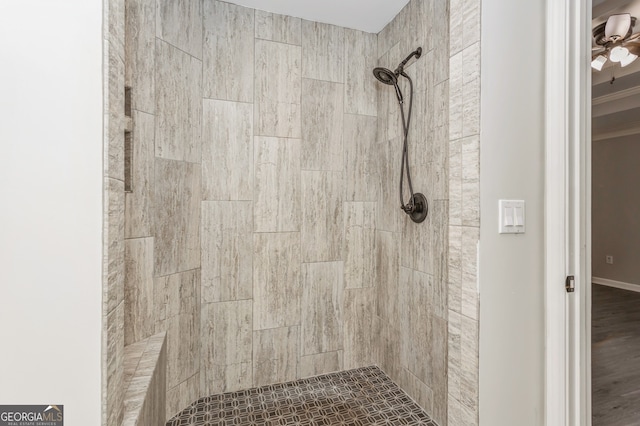 bathroom with a tile shower and ceiling fan