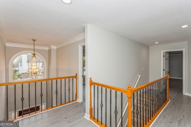 hall with a chandelier, crown molding, and light hardwood / wood-style floors