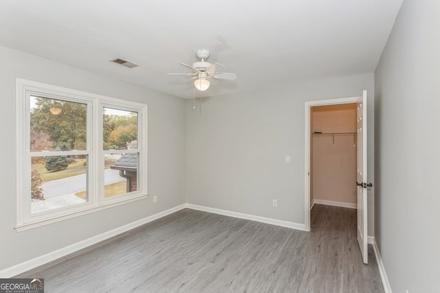 empty room with ceiling fan and light wood-type flooring