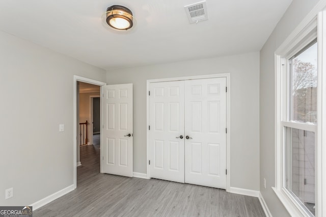 unfurnished bedroom featuring a closet and light hardwood / wood-style floors