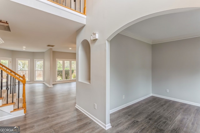 interior space with a wealth of natural light, crown molding, and dark hardwood / wood-style floors