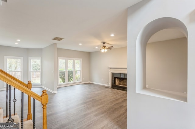 unfurnished living room with a wealth of natural light, hardwood / wood-style floors, and ceiling fan