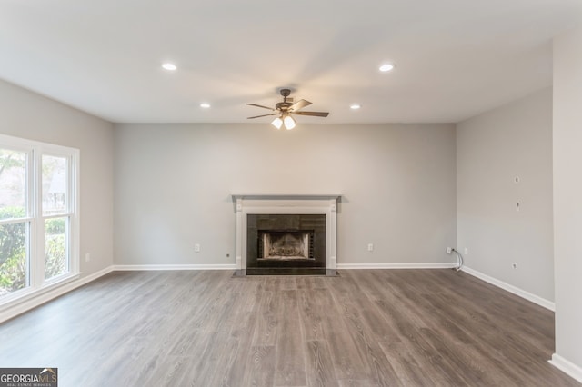 unfurnished living room with ceiling fan and wood-type flooring