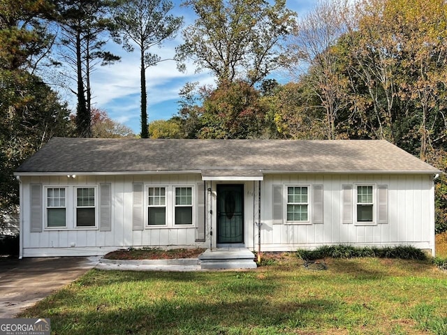 ranch-style home featuring roof with shingles, a front lawn, and board and batten siding