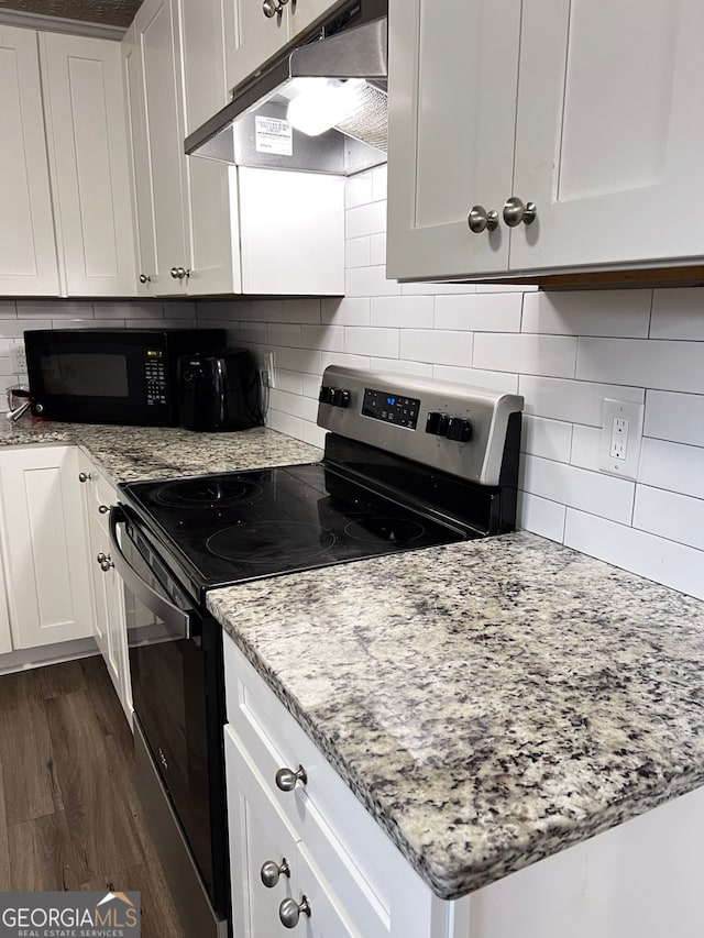 kitchen with white cabinets, dark hardwood / wood-style flooring, light stone counters, and stainless steel range with electric stovetop