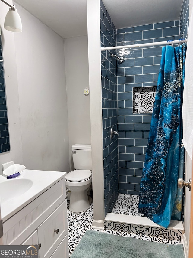 bathroom with a shower with shower curtain, tile patterned floors, vanity, and toilet