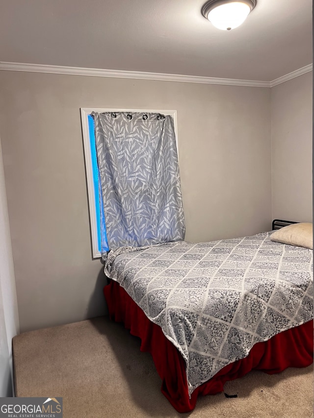 bedroom featuring ornamental molding and carpet