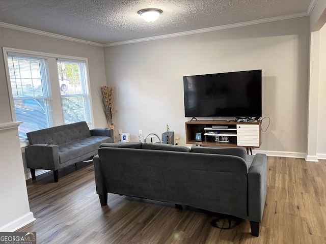 living room featuring baseboards, a textured ceiling, ornamental molding, and wood finished floors