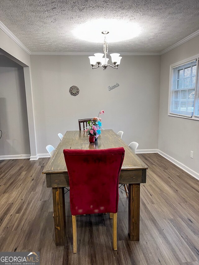 dining space featuring a textured ceiling, hardwood / wood-style flooring, crown molding, and a notable chandelier