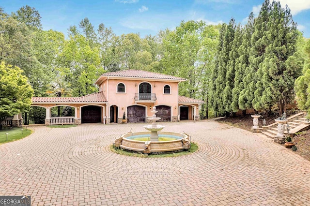 mediterranean / spanish-style house featuring a garage and a balcony