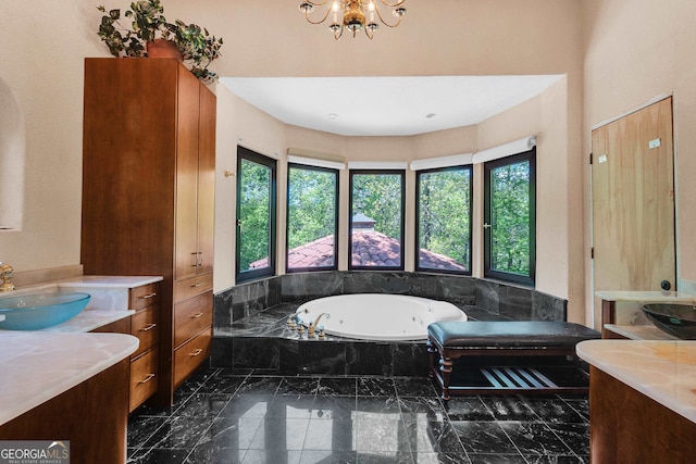 bathroom featuring vanity, a notable chandelier, and tiled tub