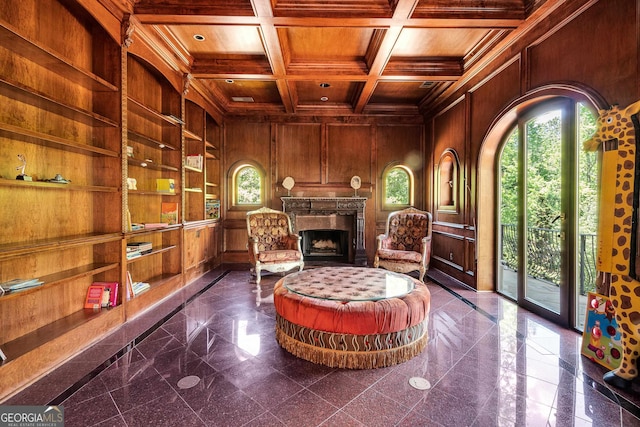 living area featuring wood walls, coffered ceiling, wooden ceiling, and a wealth of natural light