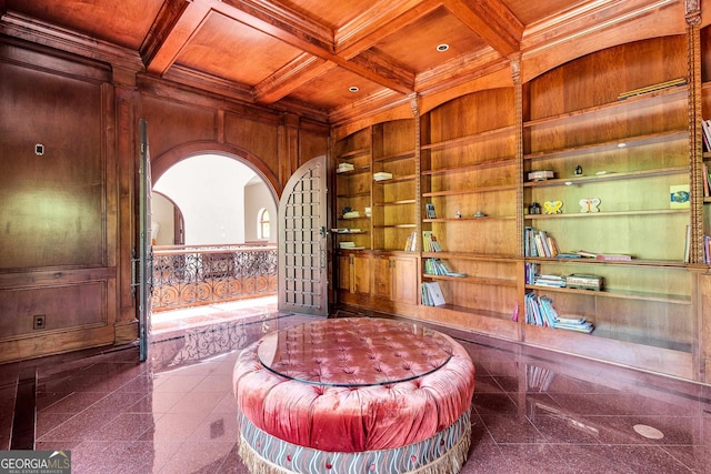 interior space with built in features, coffered ceiling, wooden ceiling, wooden walls, and crown molding