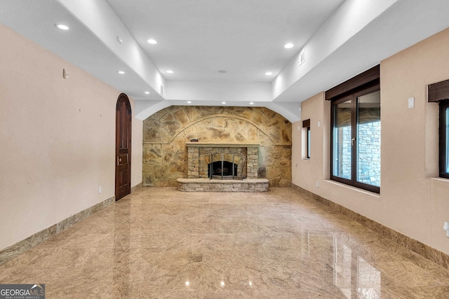 unfurnished living room with a stone fireplace