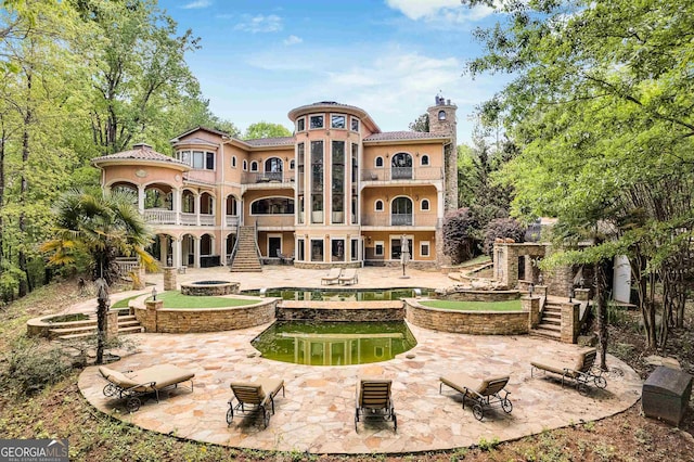 rear view of property with a patio and a balcony