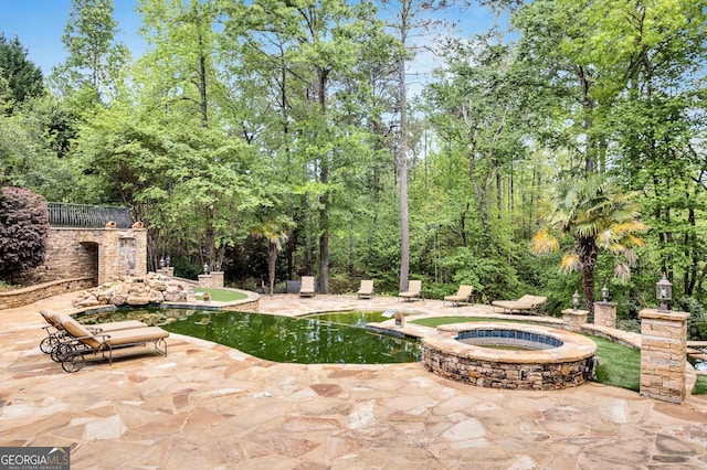 view of patio / terrace with a swimming pool with hot tub