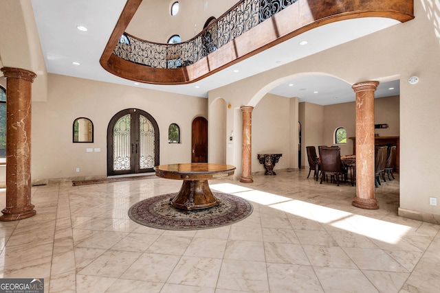 entryway with french doors, ornate columns, and a healthy amount of sunlight