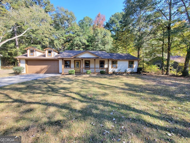 view of front of house with covered porch, a front yard, and a garage