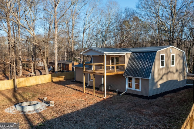 rear view of property featuring an outdoor fire pit