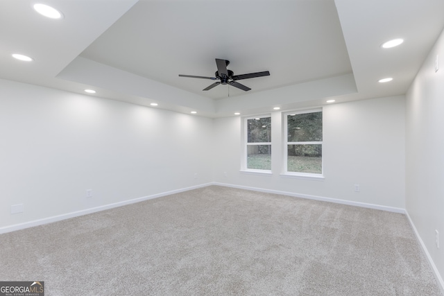 unfurnished room featuring carpet floors, ceiling fan, and a tray ceiling