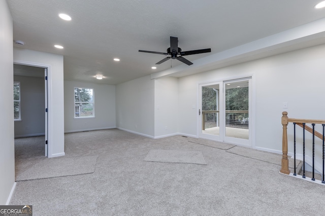 carpeted spare room with ceiling fan