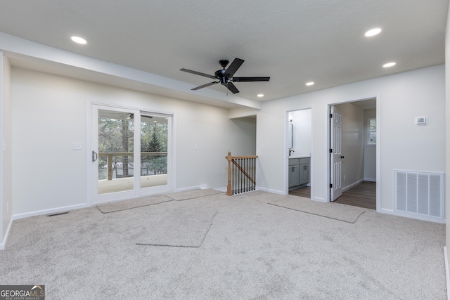 unfurnished room with ceiling fan and carpet