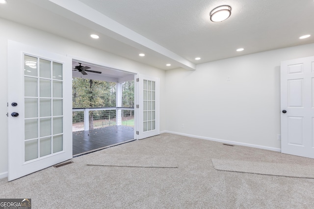 carpeted empty room with a textured ceiling, french doors, and ceiling fan