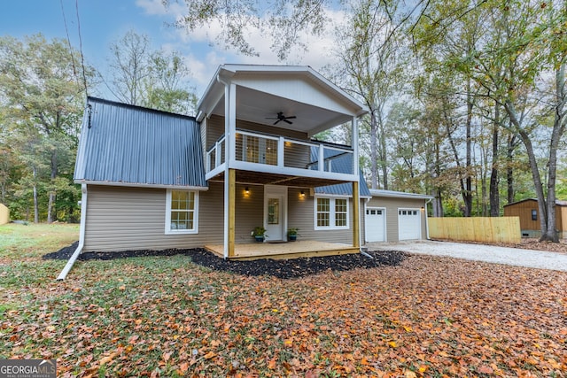 view of front facade featuring ceiling fan, a garage, a balcony, and a sunroom