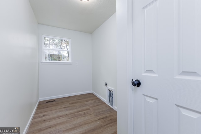 laundry area featuring light hardwood / wood-style flooring and hookup for an electric dryer