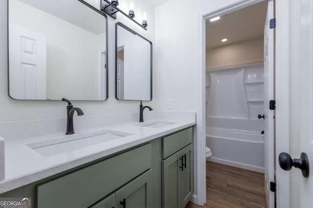 full bathroom featuring wood-type flooring, toilet, tub / shower combination, and vanity