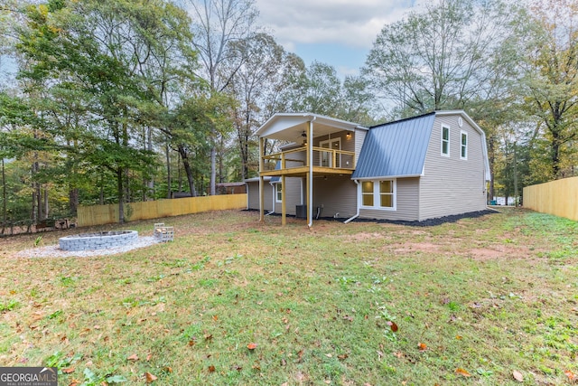 rear view of property with a lawn and ceiling fan