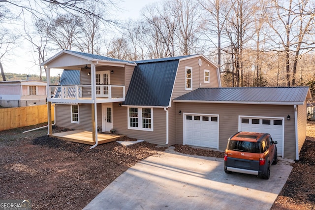 view of front of property featuring a garage, a balcony, and ceiling fan