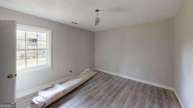 empty room featuring hardwood / wood-style floors and a textured ceiling