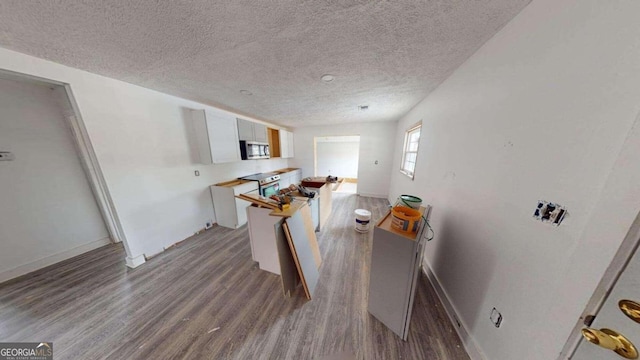 kitchen featuring white cabinetry, a textured ceiling, appliances with stainless steel finishes, and wood-type flooring