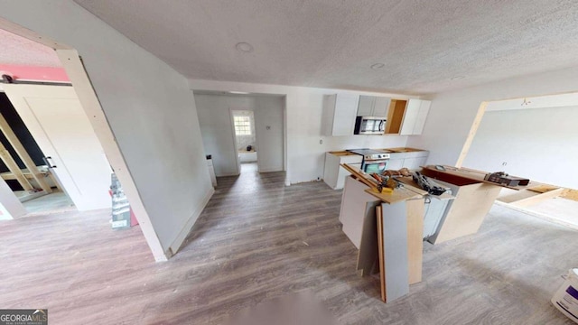 unfurnished dining area with a textured ceiling, light wood-type flooring, and a barn door