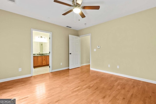 unfurnished bedroom featuring light hardwood / wood-style flooring, ensuite bathroom, and ceiling fan