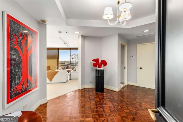 corridor with a notable chandelier and dark parquet floors