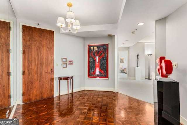 entryway featuring an inviting chandelier and dark parquet flooring