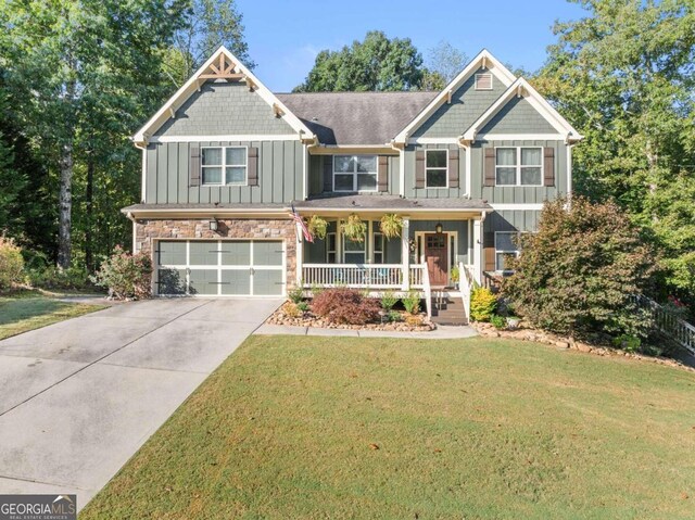 craftsman inspired home featuring a garage, a front lawn, and a porch