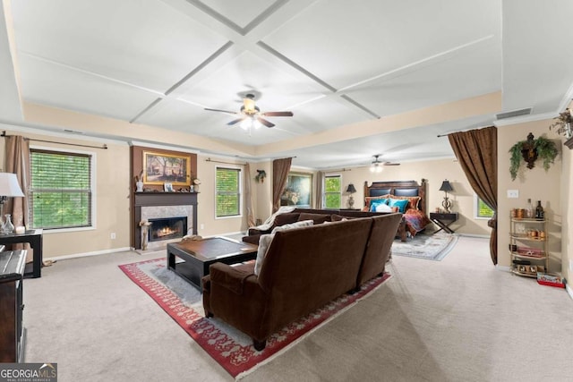 carpeted living area with plenty of natural light, coffered ceiling, a fireplace, and visible vents