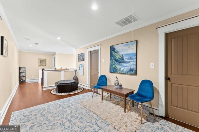 sitting room with hardwood / wood-style flooring and ornamental molding