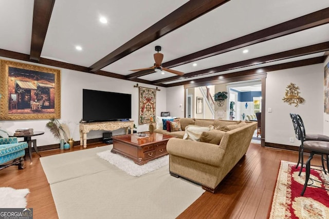 living room featuring beamed ceiling, hardwood / wood-style flooring, and ceiling fan