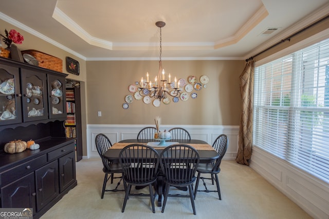 carpeted dining area with ornamental molding, a notable chandelier, and a raised ceiling