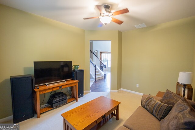 living room with light colored carpet and ceiling fan