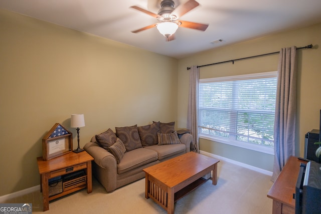 carpeted living room with ceiling fan