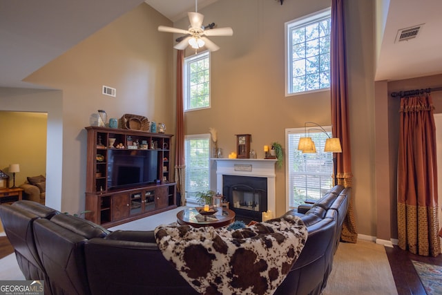 living room with ceiling fan, high vaulted ceiling, and a wealth of natural light